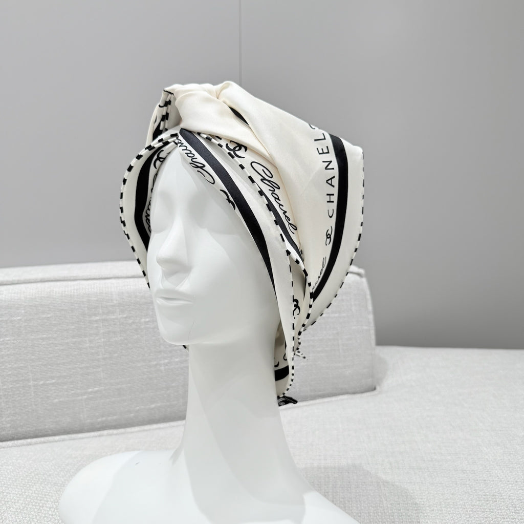 Chanel scarf on a mannequin head against a gray background